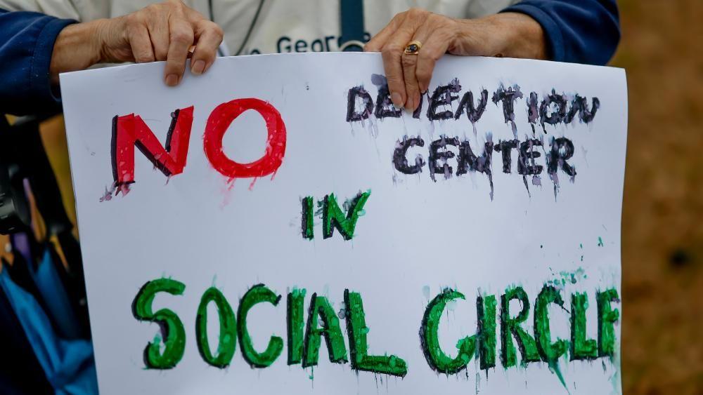 Un participante sostiene un cartel que dice "NO al centro de detenci&oacute;n en Social Circle", durante una manifestaci&oacute;n contra el centro de detenci&oacute;n propuesto por el Servicio de Inmigraci&oacute;n y Control de Aduanas de Estados Unidos.