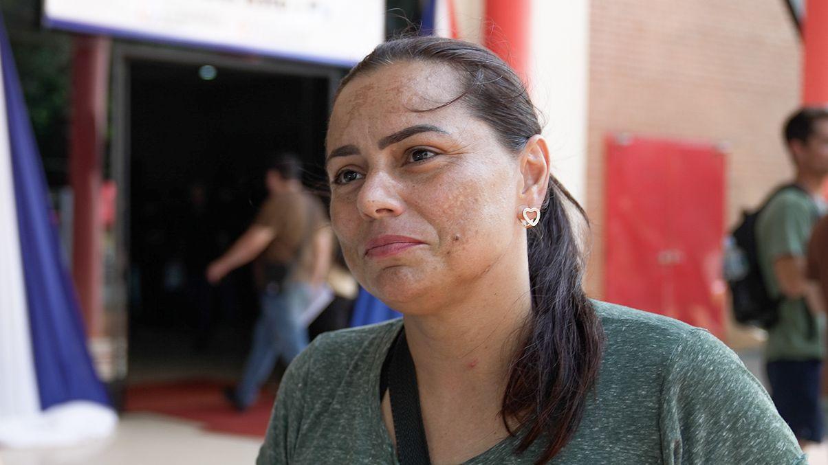 Marluize Avila, una mujer de piel trigue&ntilde;a y cabello liso, frente a la entrada de un edificio.