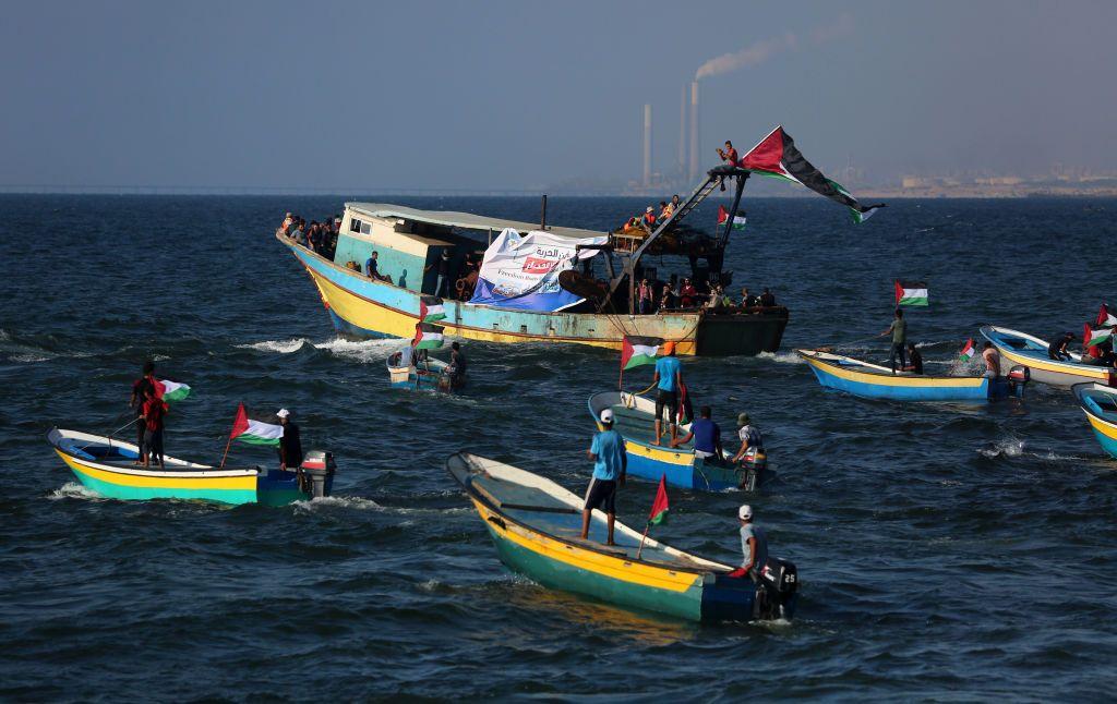 Peque&ntilde;os barcos de pesca con banderas palestinas en agua del mar. 