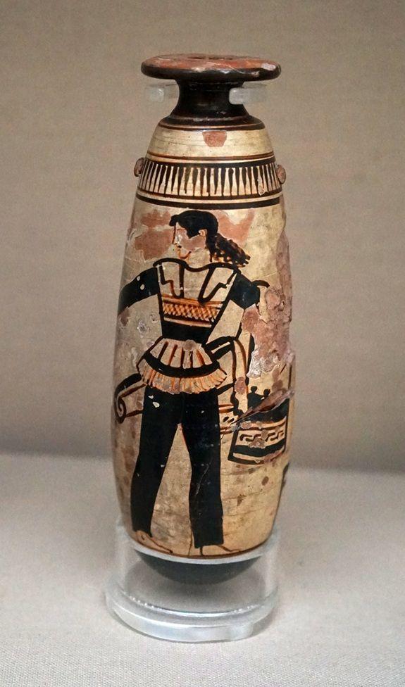 Un vaso de colores dorado y negro en el que est&aacute; dibujada una mujer con unos pantalones negros