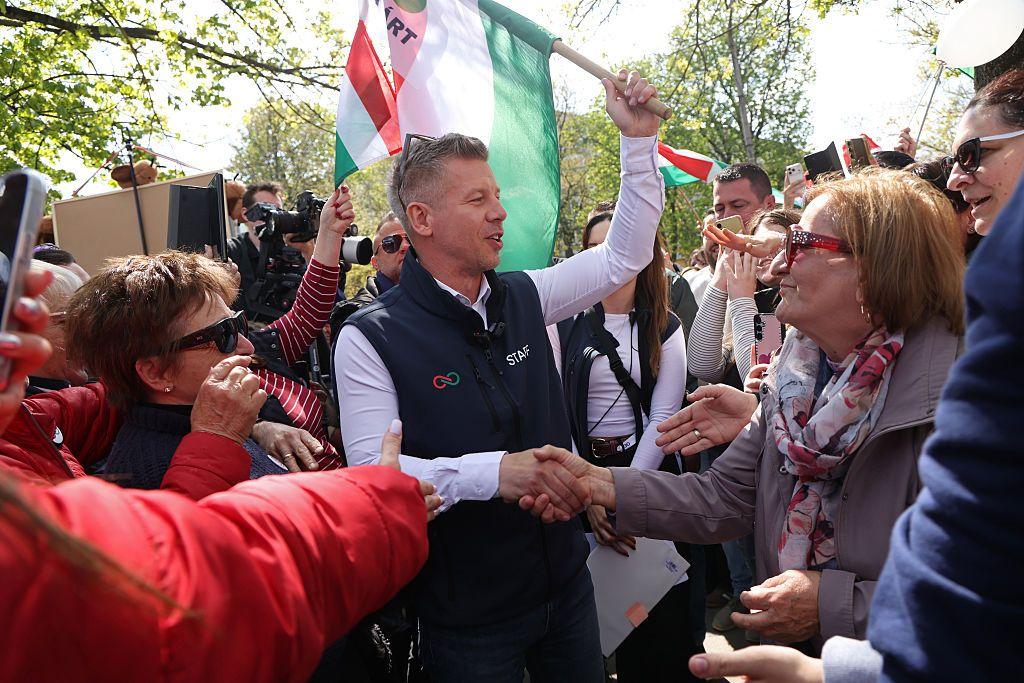 Peter Magyar sujeta en alto una bandera de Hungr&iacute;a rodeado de seguidores. 