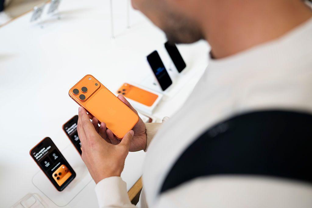 Un usuario el la tienda de Apple toma un nuevo iPhone 17 en sus manos.
