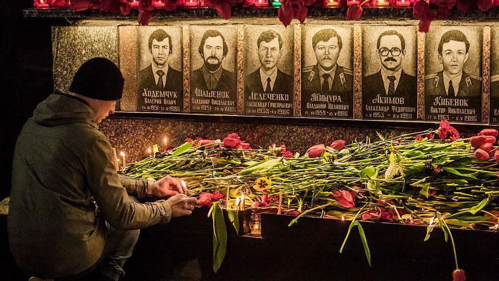 Un hombre rinde homenaje a los bomberos fallecidos por el desastre. 