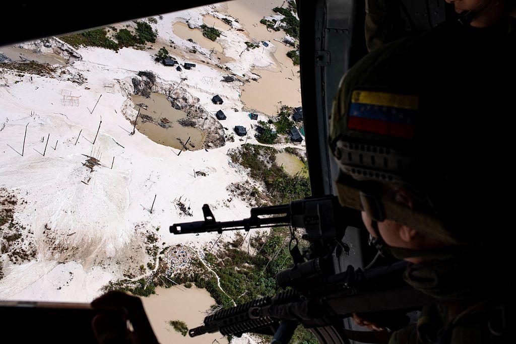 Un militar venezolano ve desde un helic&oacute;ptero una zona devastada por la miner&iacute;a ilegal en el estado Amazonas.