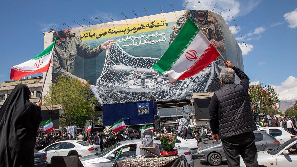 Los iran&iacute;es portan banderas nacionales mientras se congregan en la Plaza de la Revoluci&oacute;n de Teher&aacute;n, despu&eacute;s de que Estados Unidos e Ir&aacute;n acordaran un alto el fuego de dos semanas, el 8 de abril de 2026 en Teher&aacute;n, Ir&aacute;n.