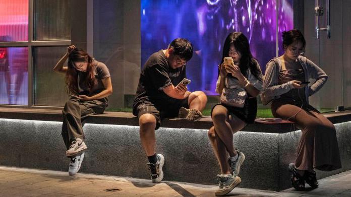 J&oacute;venes sentados en una plaza en Pek&iacute;n