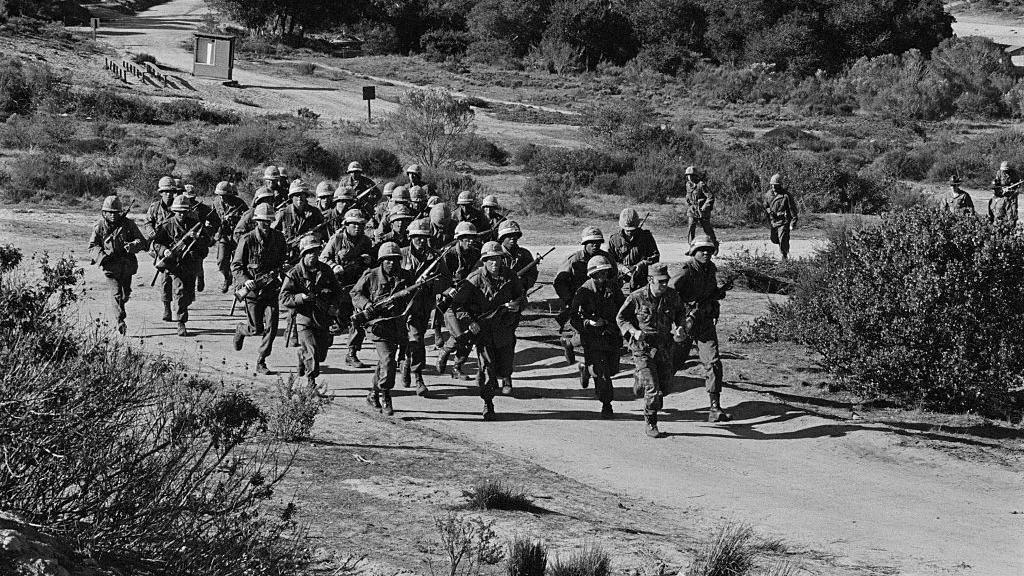 Soldados estadounidenses corren con armas en la mano (foto en blanco y negro)