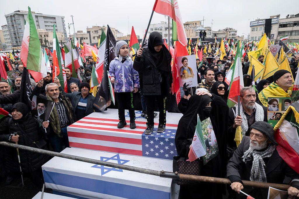 Ni&ntilde;os iran&iacute;es se ponen de pie sobre ata&uacute;des que simbolizan los de soldados estadounidenses e israel&iacute;es, mientras participan en una manifestaci&oacute;n para conmemorar el D&iacute;a Internacional de Al-Quds &mdash;tambi&eacute;n conocido como el D&iacute;a de Jerusal&eacute;n&mdash; en Teher&aacute;n, Ir&aacute;n, el 13 de marzo de 2026.