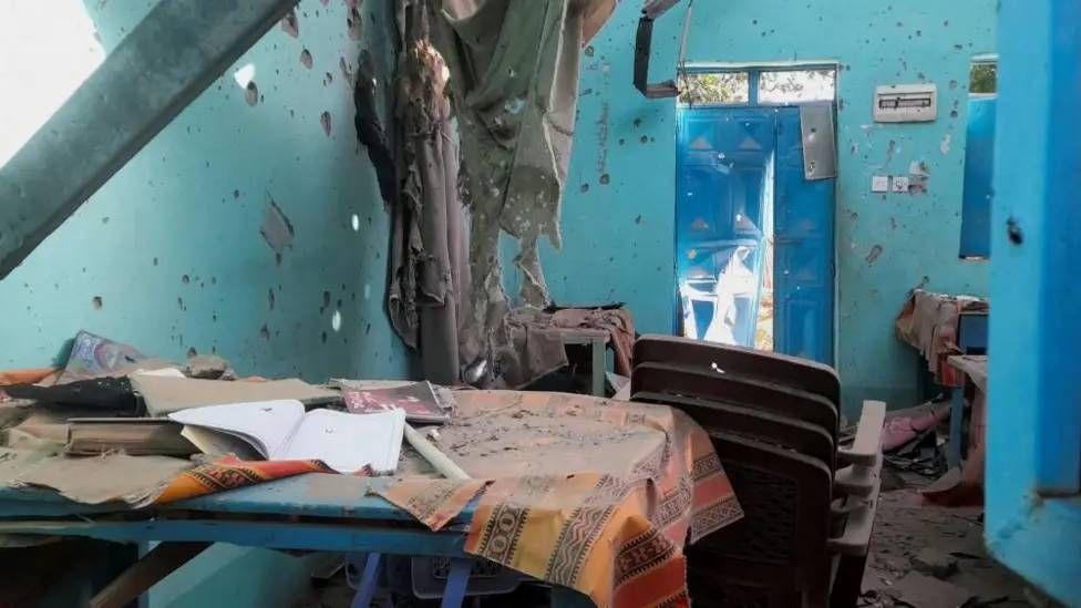 Un sal&oacute;n de clase destruido con las paredes perforadas por balas