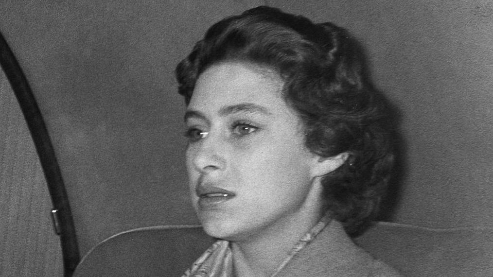 Imagen cerrada de una mujer con pelo  corto negro dentro de un autom&oacute;vil con expresi&oacute;n de angustia.