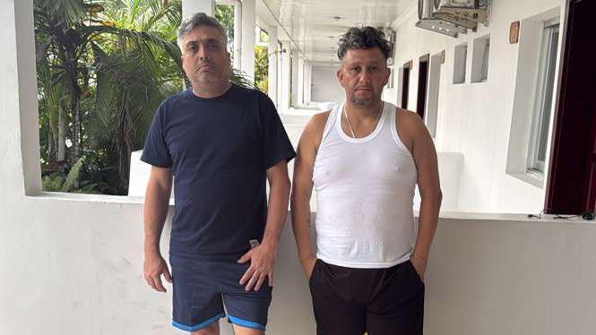 Carlos Alberto Rodelo y Jorge Cubillos en un hotel de Kinshasa, vestidos con franelas y shorts. 