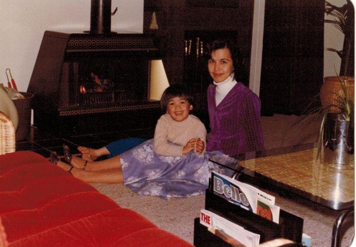 Terence Tao, de cinco a&ntilde;os, est&aacute; recostado sobre su madre, quien se encuentra sentada en el suelo que est&aacute; cubierto por una alfombra beige. Al lado hay una chimenea, al otro lado una mesa con una planta y al frente un sof&aacute; rojo. Ambos sonr&iacute;en a la c&aacute;mara. Ella lleva un saco morado y una falda azul y &eacute;l un saco beige