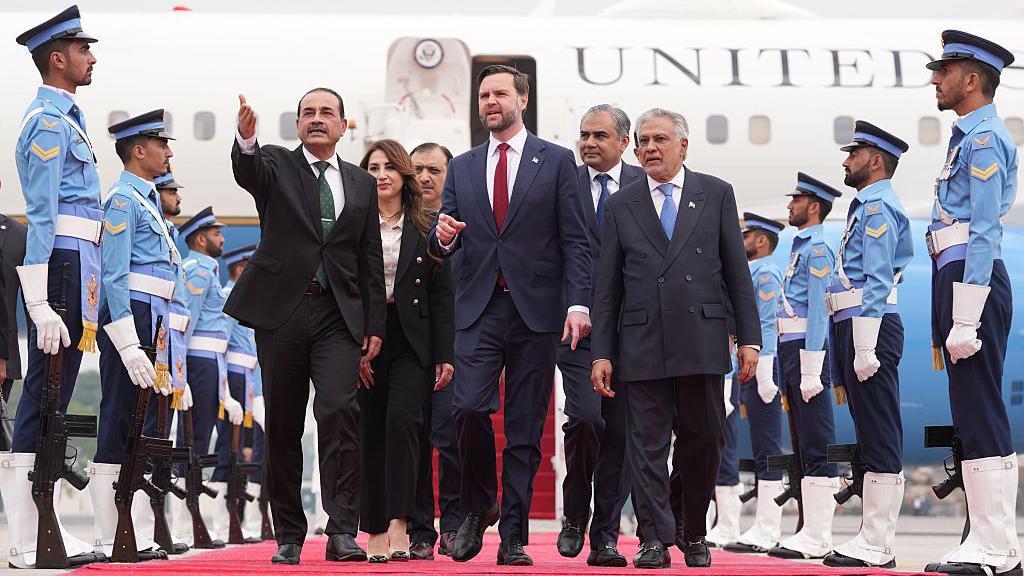 El vicepresidente de los Estados Unidos, JD Vance (centro), camina junto al jefe de las Fuerzas de Defensa y jefe del Estado Mayor del Ej&eacute;rcito de Pakist&aacute;n, el mariscal de campo Asim Munir (izquierda), y al vice primer ministro y ministro de Asuntos Exteriores paquistan&iacute;, Mohammad Ishaq Dar, a lo largo de una alfombra roja tras descender de una aeronave.