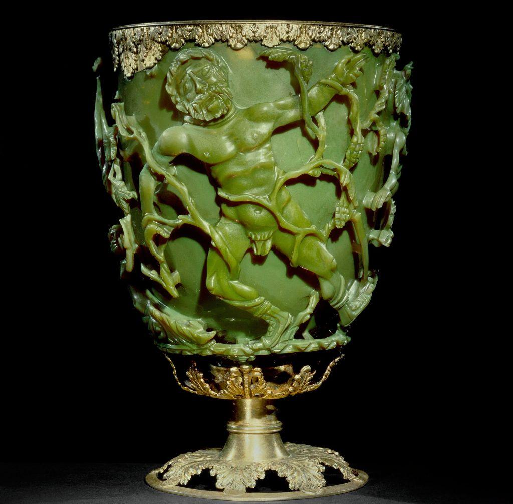 Copa para beber; de vidrio verde; cubierta con diversas escenas que representan la muerte del rey Licurgo; el borde est&aacute; adornado con una banda de plata dorada con motivos de hojas, adem&aacute;s de una base de plata dorada con hojas de vid caladas.
