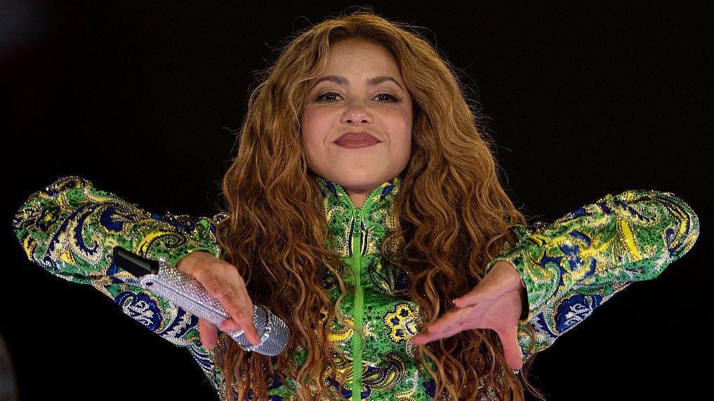Shakira dando un concierto en la playa de Copacabana en 2026 luciendo un traje alusivo a los colores de la bandera de Brasil. 