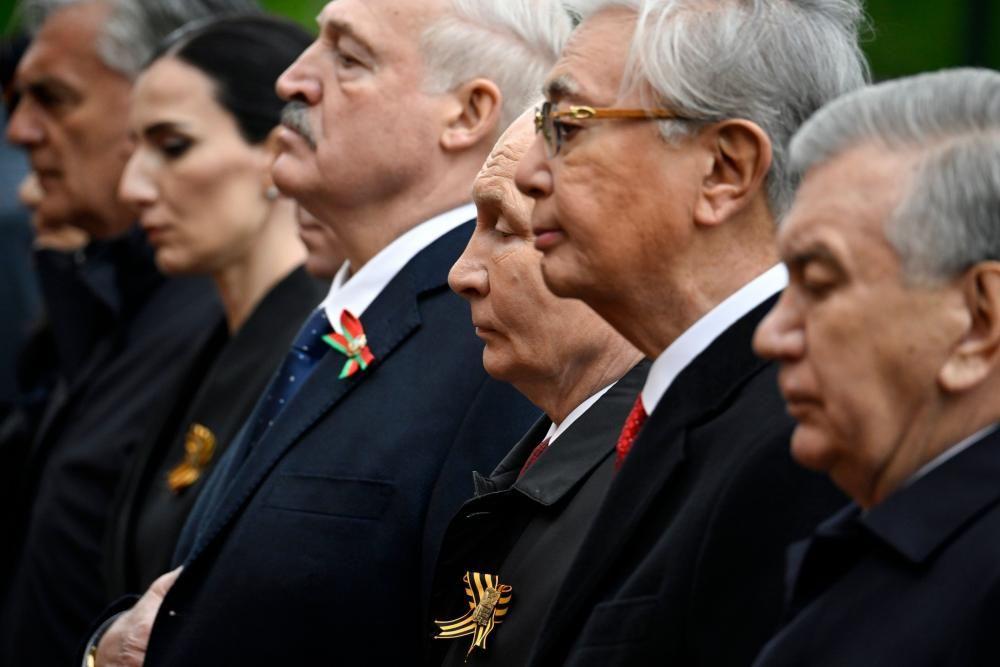 Vista lateral de Vlad&iacute;mir Putin de pie en fila junto a otros l&iacute;deres extranjeros, entre ellos Alexander Lukashenko, de Bielorrusia.