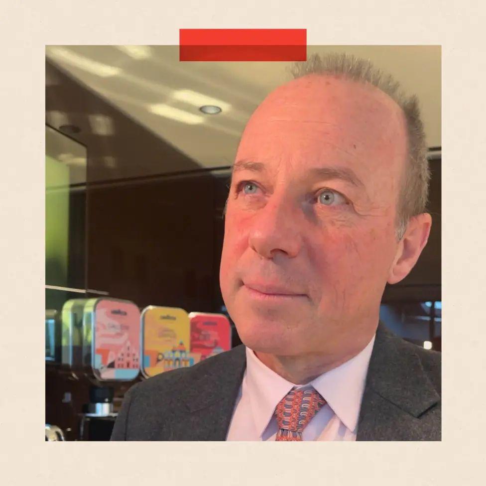 Foto de la cara de Giuseppe Lavazza en primer plano, y en el fondo se ve que est&aacute; en una de sus cafeter&iacute;as