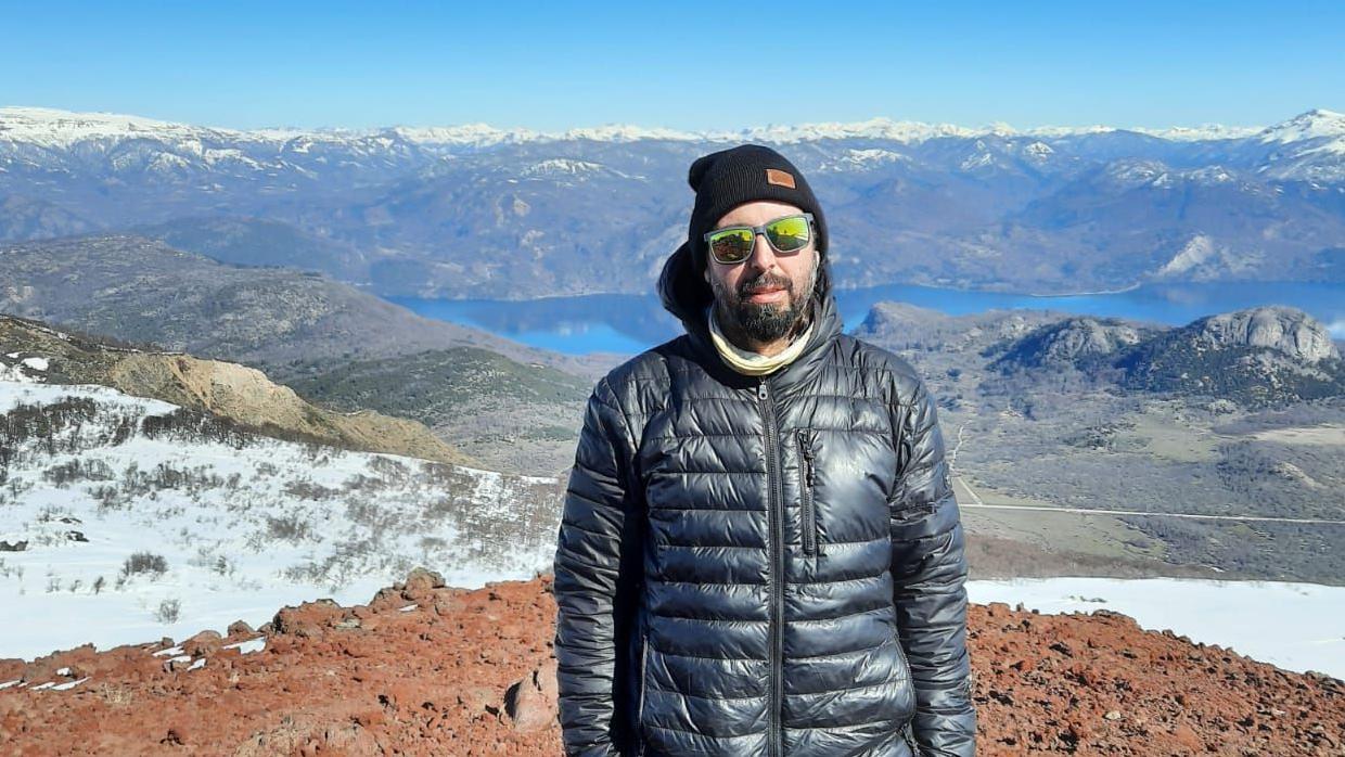 Hombre con gafas de sol y casaca en una monta&ntilde;a en la Patagonia argentina.