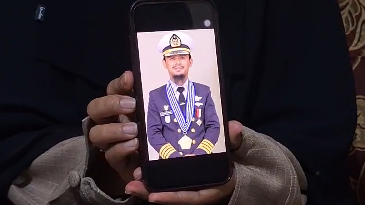 Santi Sanaya sostiene su tel&eacute;fono, mostrando una foto de su esposo, el capit&aacute;n Ashari Samadikun, quien fue tomado como reh&eacute;n por piratas somal&iacute;es el 21 de abril de 2026.