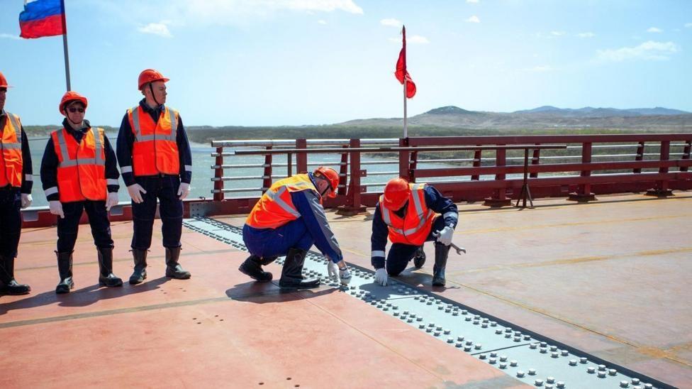 Dos funcionarios revisan los avances en el puente que se cosntruye entre Rusia y Corea del Norte. 