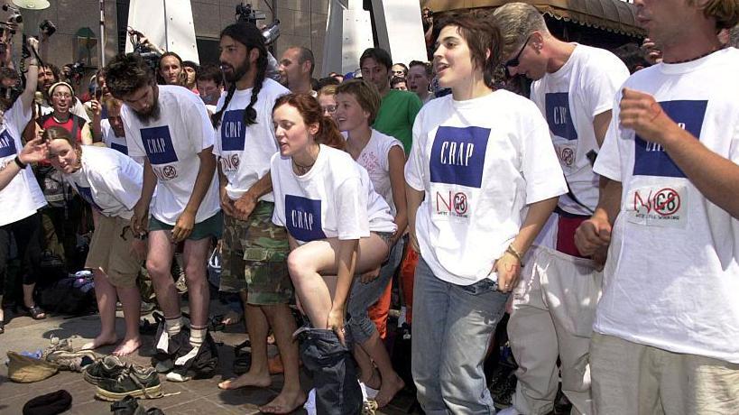 Manifestantes anti-G8 se quitan la ropa durante una protesta frente a la tienda Gap en Calgary, Alberta, Canad&aacute;, antes del inicio de la Cumbre del G8 de 2002.