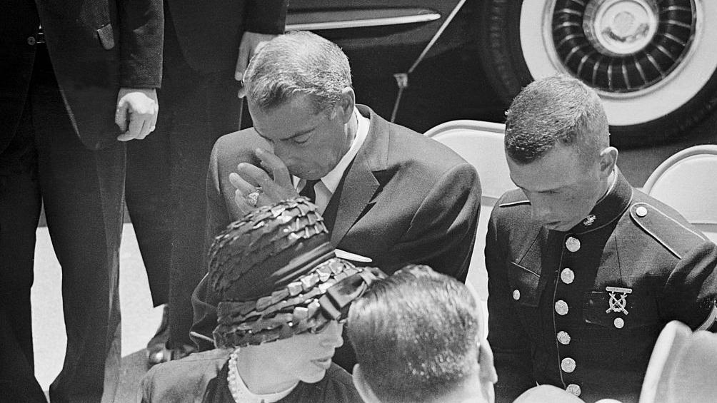 Joe DiMaggio cabizbajo, acompa&ntilde;ado de su hijo, durante el funeral de Marilyn Monroe el 14 de agosto de 1962