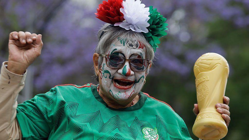 Aficionada mexicana con una r&eacute;plica de la Copa del Mundo.