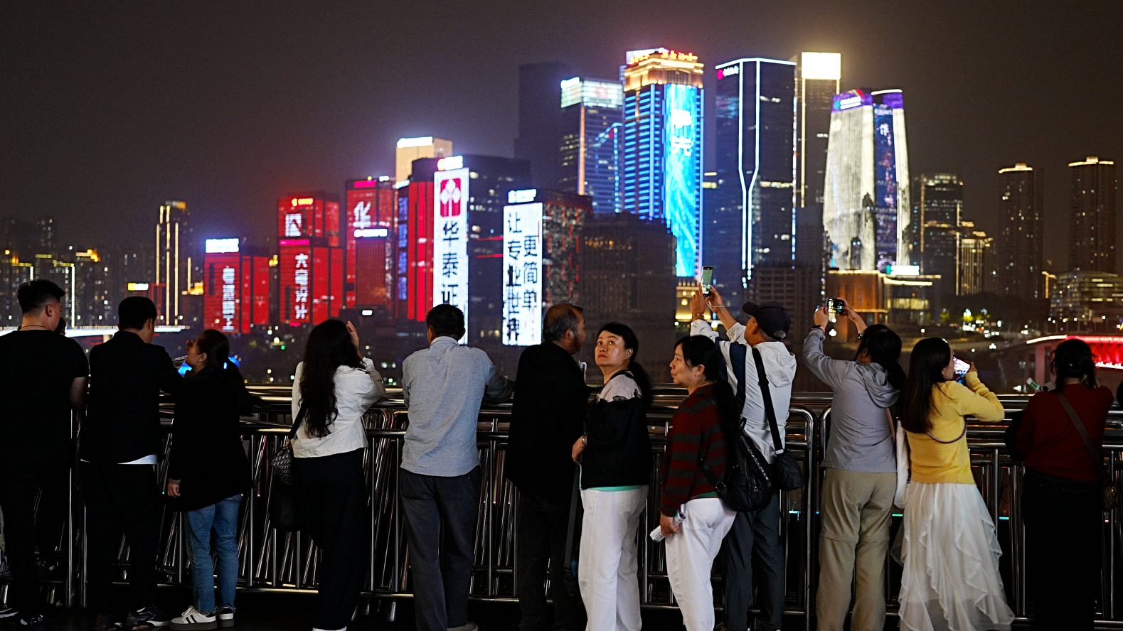 Turistas que buscan una foto del famoso horizonte de ne&oacute;n de Chongqing.