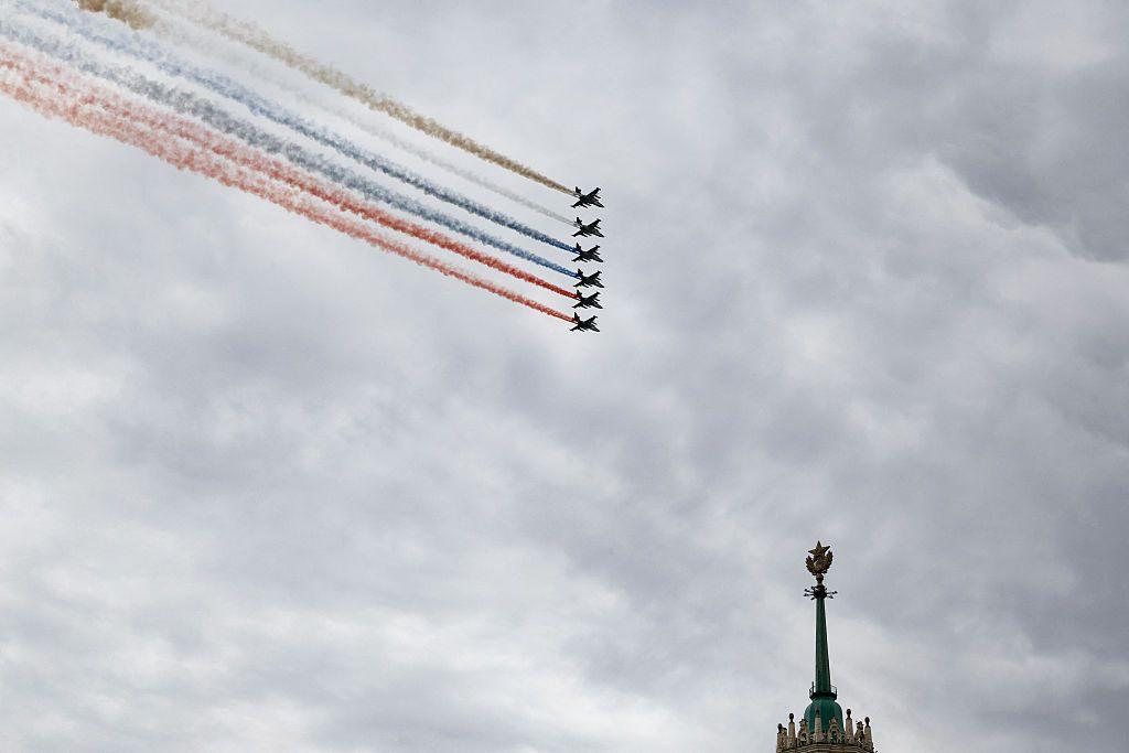 Aviones de combate rusos lanzan humo con los colores de la bandera rusa mientras sobrevuelan el centro de Mosc&uacute;; en la imagen se aprecia la parte superior de la c&uacute;pula de un edificio.
