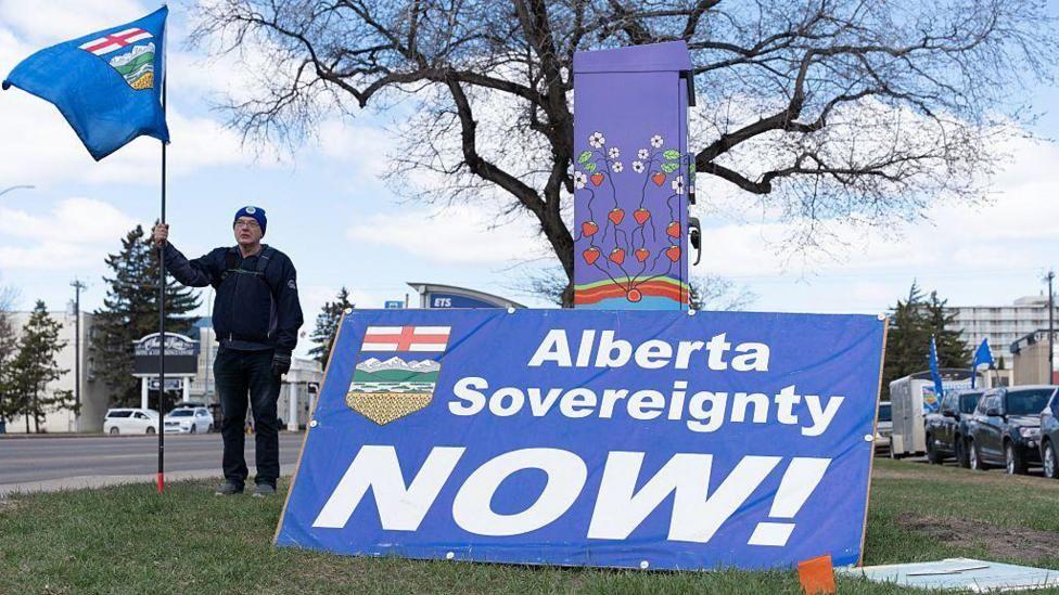 Un partidario separatista sostiene una bandera durante una manifestaci&oacute;n cerca de la sede de Elections Alberta en Edmonton, Canad&aacute;, el 4 de mayo de 2026