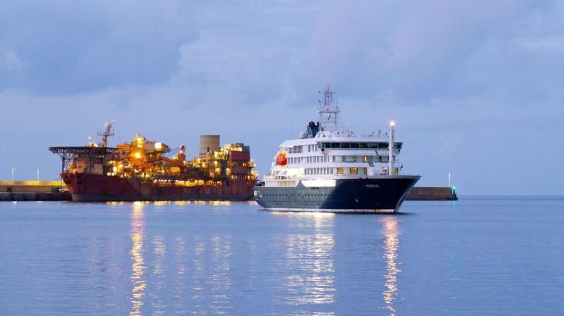 El crucero HM Hondius fondeado en aguas de las Islas Canarias, Espa&ntilde;a. Contra el muelle hay otra embarcaci&oacute;n iluminada