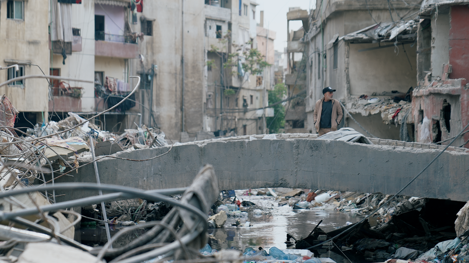 Un hombre parado en un puente inspecciona la destrucci&oacute;n en Beirut tras el ataque del 8 de abril.