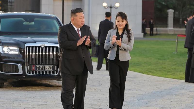Kim Jong Un con su hija caminando mientras aplauden.