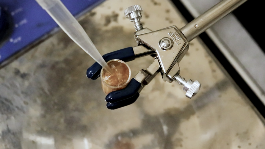 Una pipeta est&aacute; sostenida cerca de un tubo de ensayo que contiene un gel marr&oacute;n. Forma parte de un experimento de almacenamiento molecular de energ&iacute;a solar t&eacute;rmica en la Universidad de California, Santa B&aacute;rbara