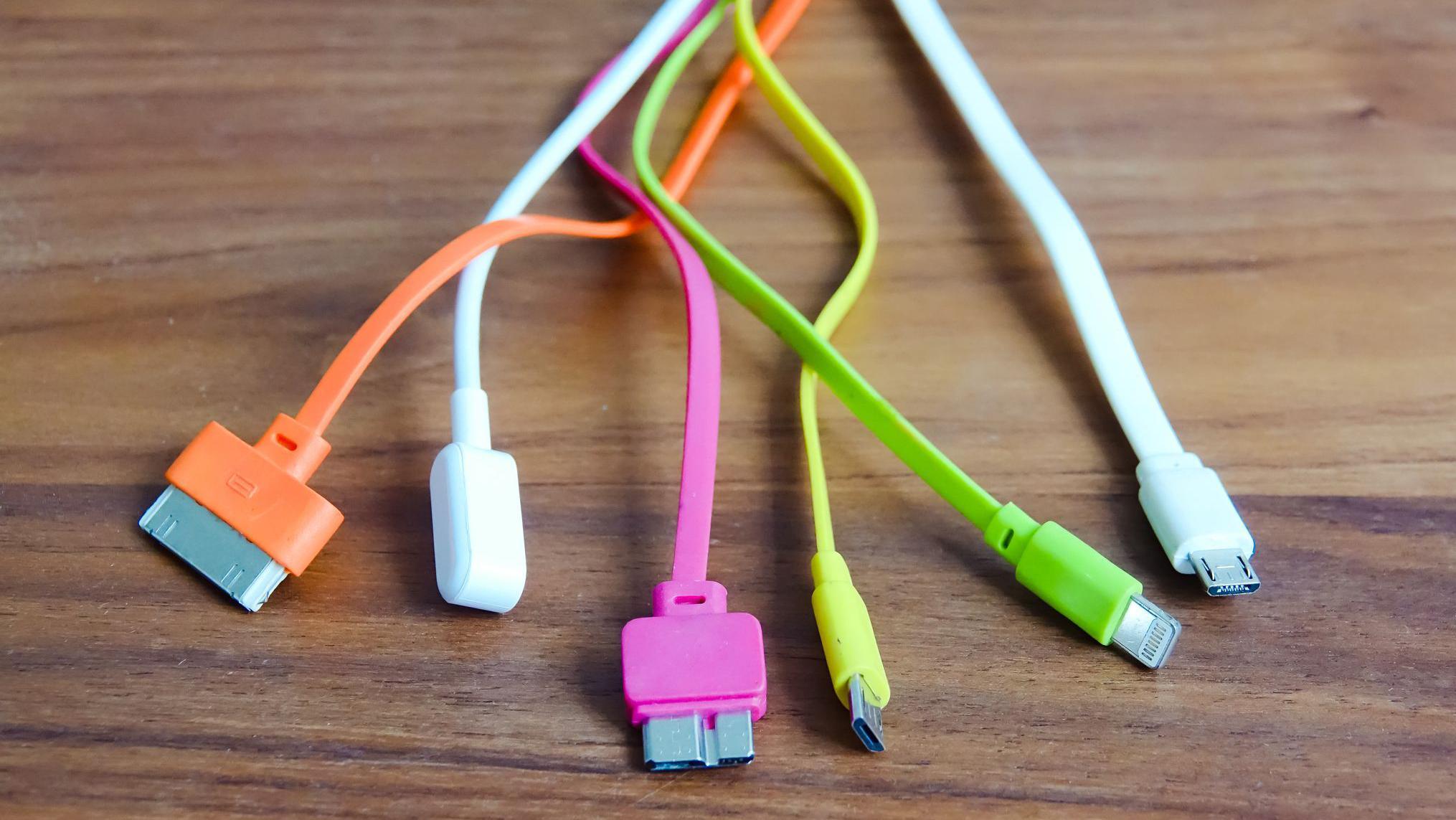 Cables de varios colores apoyados sobre una mesa. 