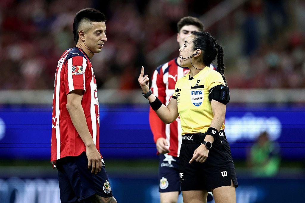 Katia Itzel Garc&iacute;a habla con un jugador del Guadalajara en la Liga Mx