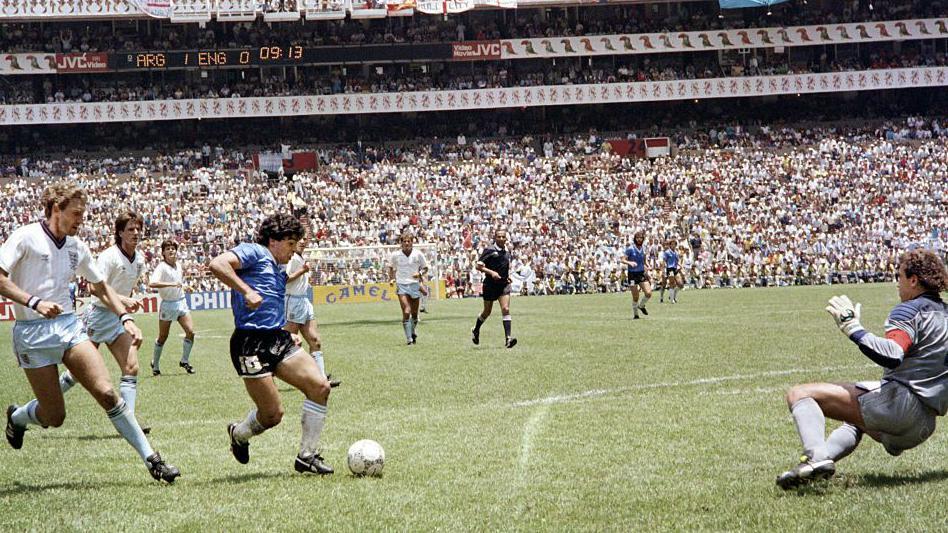 Se ve a Maradona regateando el bal&oacute;n a trav&eacute;s de varios futbolistas ingleses y se ve al portero ingl&eacute;s lanz&aacute;ndose hacia un lateral.