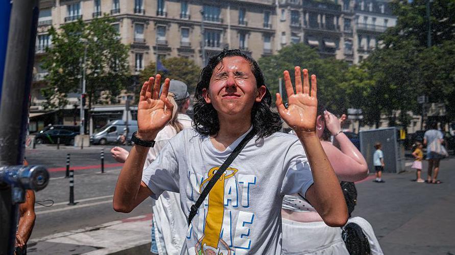 Un joven se refresca en Par&iacute;s.