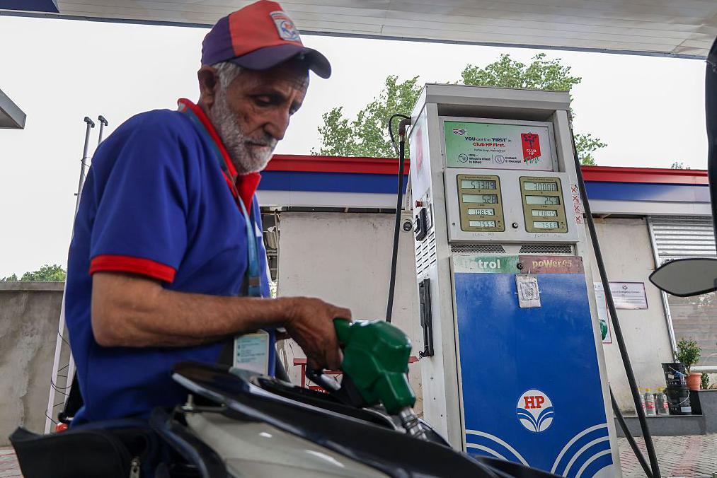 Un empleado llena el tanque de una moto mientras se exhiben los precios del combustible, reci&eacute;n aumentados, en una estaci&oacute;n de servicio de Hindustan Petroleum en Srinagar, Jammu y Cachemira, el 25 de mayo de 2026.