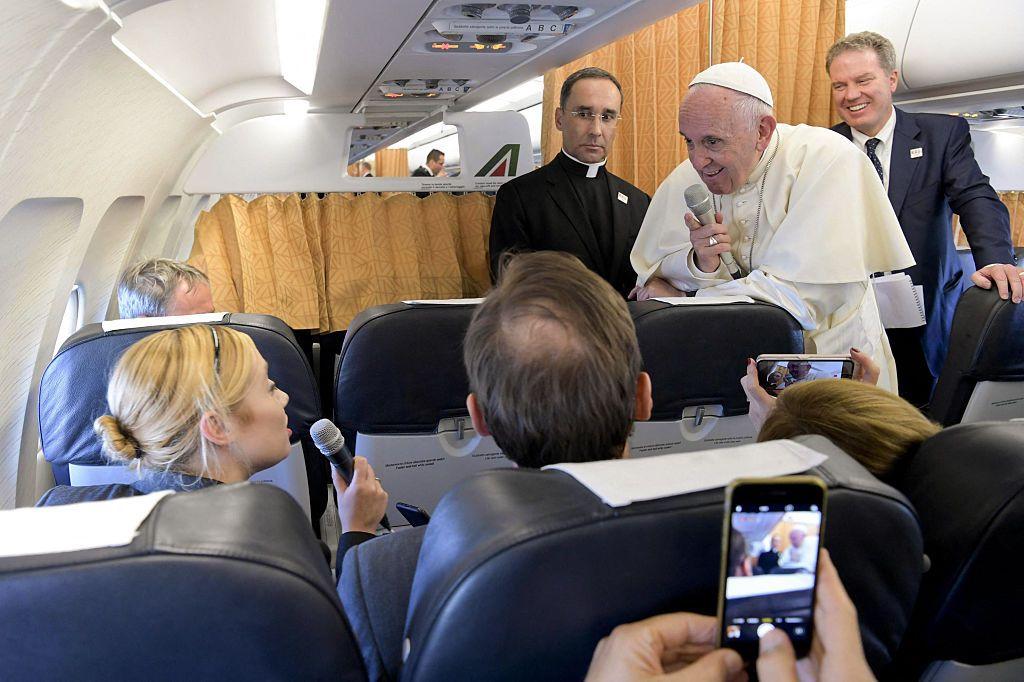 El Papa Francisco responde a una periodista en un avi&oacute;n durante uno de sus viajes.