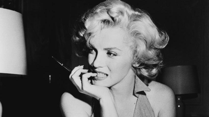 Marilyn Monroe con la cabeza ladeada y la barbilla apoyada en la mano