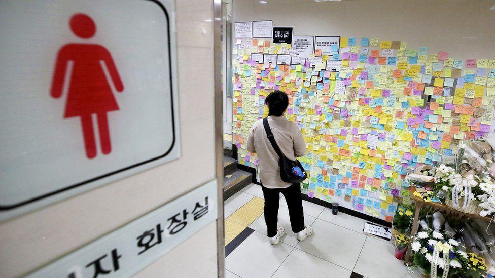 Una persona lee los mensajes en la pared de un ba&ntilde;o de mujeres en Corea del Sur. 
