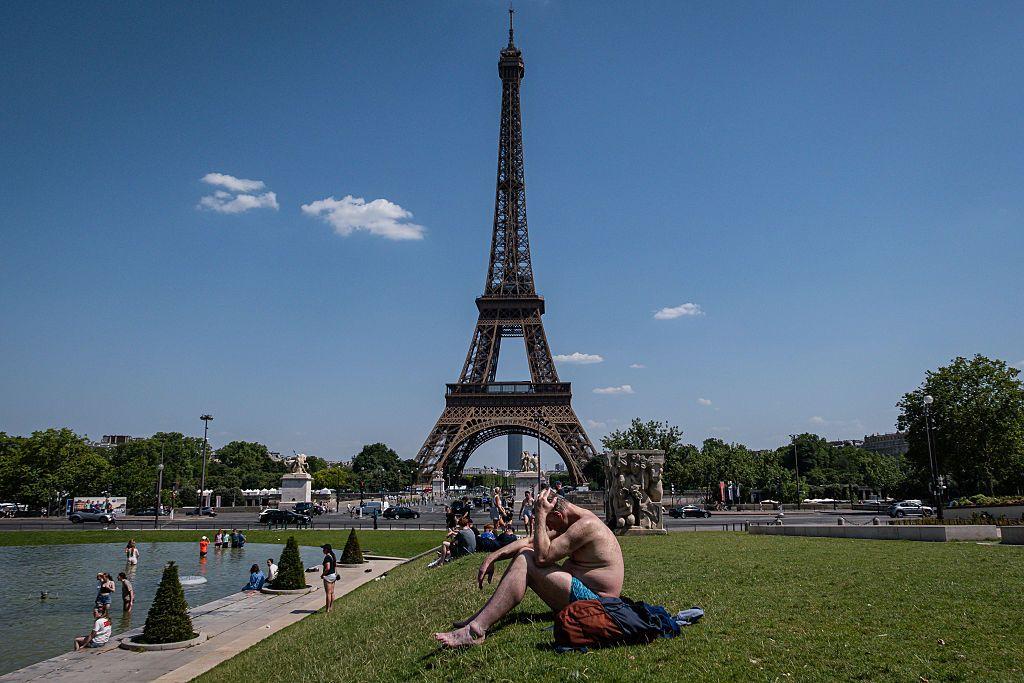 La torre Eiffel de Par&iacute;s rodeada de personas que sufren el calor intenso