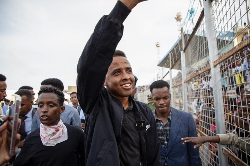 El &aacute;rbitro somal&iacute; Omar Abdulkadir saluda rodeado de varios hombres al llegar de vuelta a Somalia