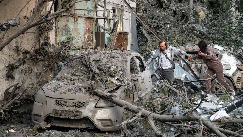 Dos personas caminan entre escombros tras un ataque con drones en Kyiv