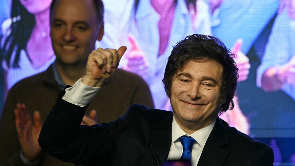 Adorni est&aacute; detr&aacute;s de un Milei sonriente