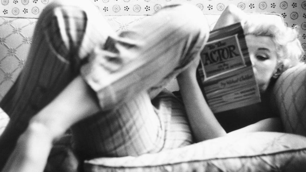 Marilyn Monroe recostada leyendo un libro