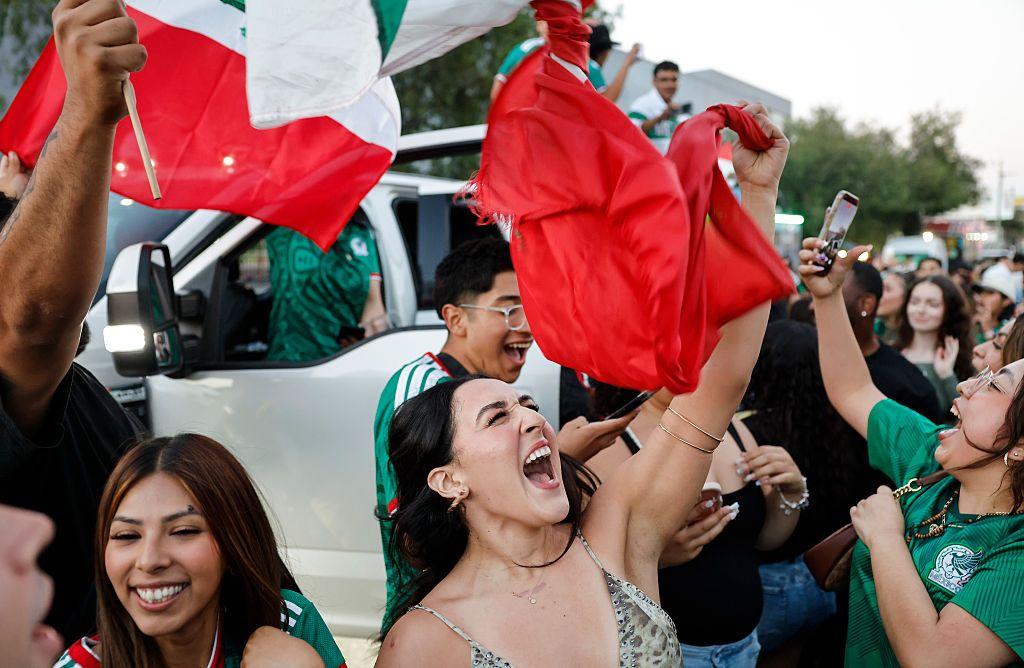 Mexicanos con la bandera celebran el triunfo de su selecci&oacute;n. 