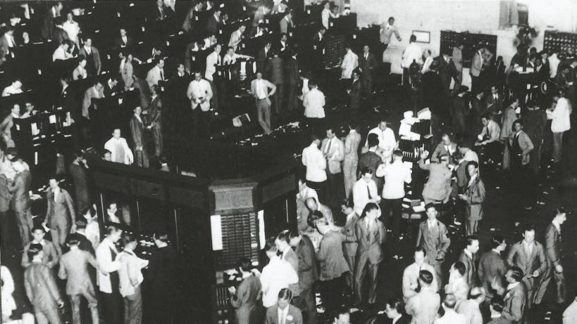 Varias decenas de comisionistas de bolsa est&aacute;n parados con expresi&oacute;n de preocupaci&oacute;n.