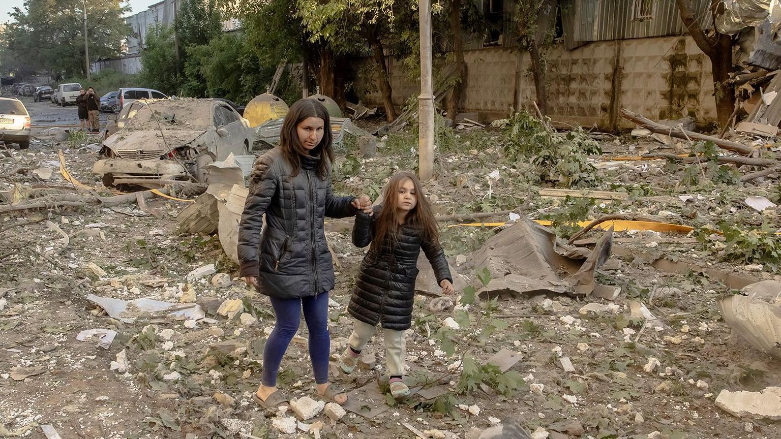 A primera hora de la ma&ntilde;ana, una mujer y una ni&ntilde;a peque&ntilde;a caminan de la mano sobre una zona de escombros y escombros en Kiev.